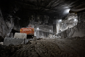 Escavatrice rossa nella cava di marmo dentro la montagna