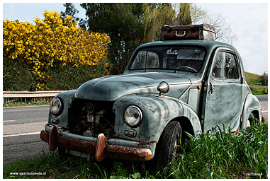 Foto di un Topolino FIAT abbandonato lungo una strada