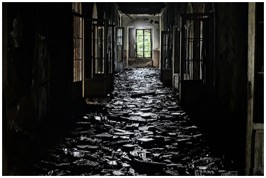 Corridoio ricoperto di detriti nel manicomio abbandonato di Volterra