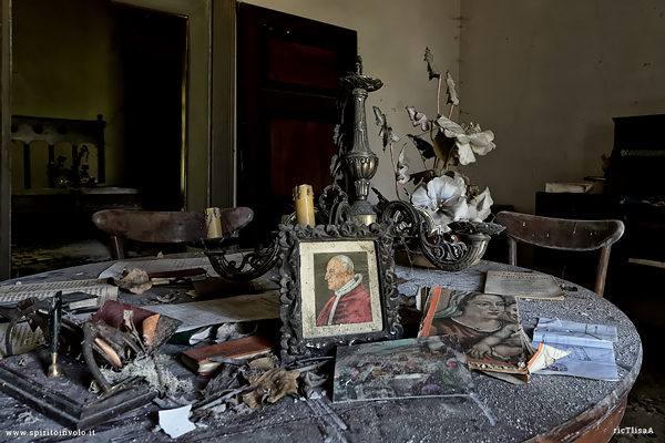 Tavolo con foto del papa nella casa abbandonata del parroco