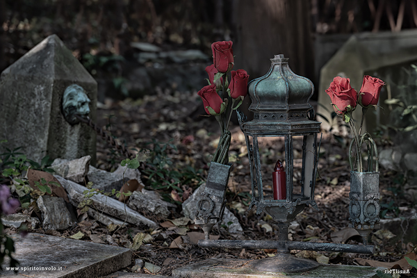 Lumi e fiori tra le tombe nel cimitero della castagna