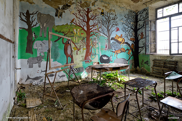 Aula con disegni della giungla in una scuola abbandonata