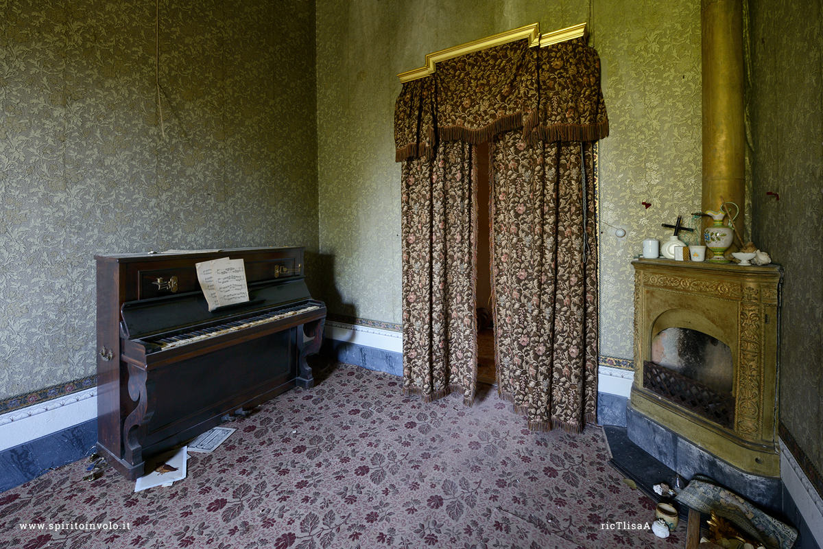 Foto di una stanza con pianoforte e caminetto nella Villa della Poetessa