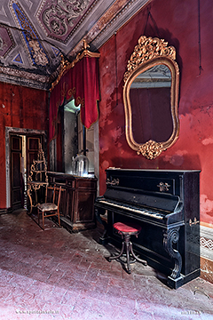 Pianoforte e specchio nel salone rosso di Villa Runia